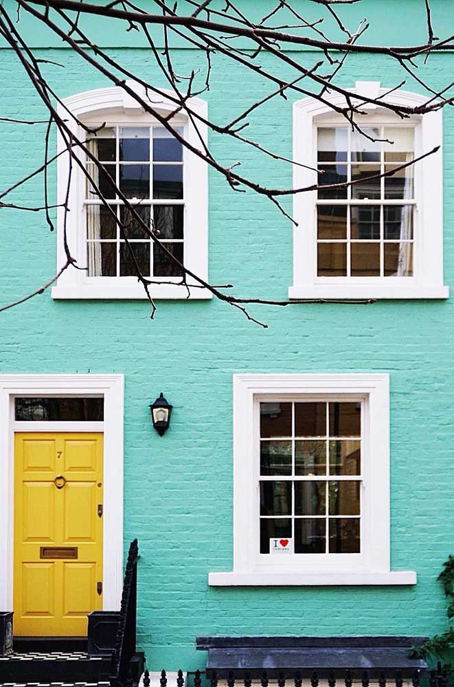 La vieille maison a pris vie et s'est colorée avec les murs bleus et la porte jaune attirant toute l'attention sur elle-même. Les cadres blancs apportent de la légèreté au design