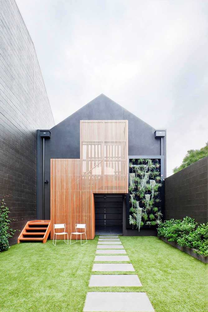 Une maison noire avec des détails en bois