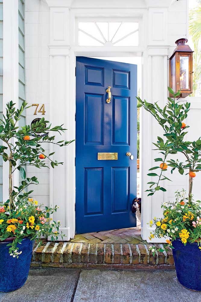 L'entrée de la maison a gagné la présence de gerberas jaunes dans le vase contrastant magnifiquement avec la porte bleu royal.