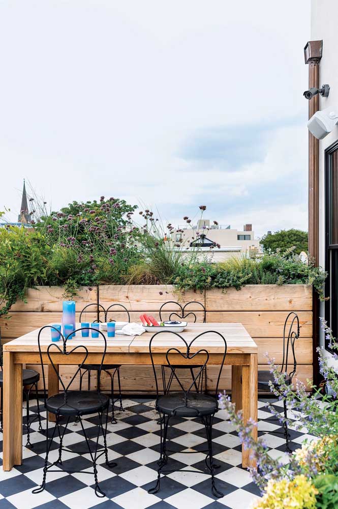 Terrasse gourmande aux airs provençaux. La haie de plantes et le sol en damier se démarquent dans ce projet