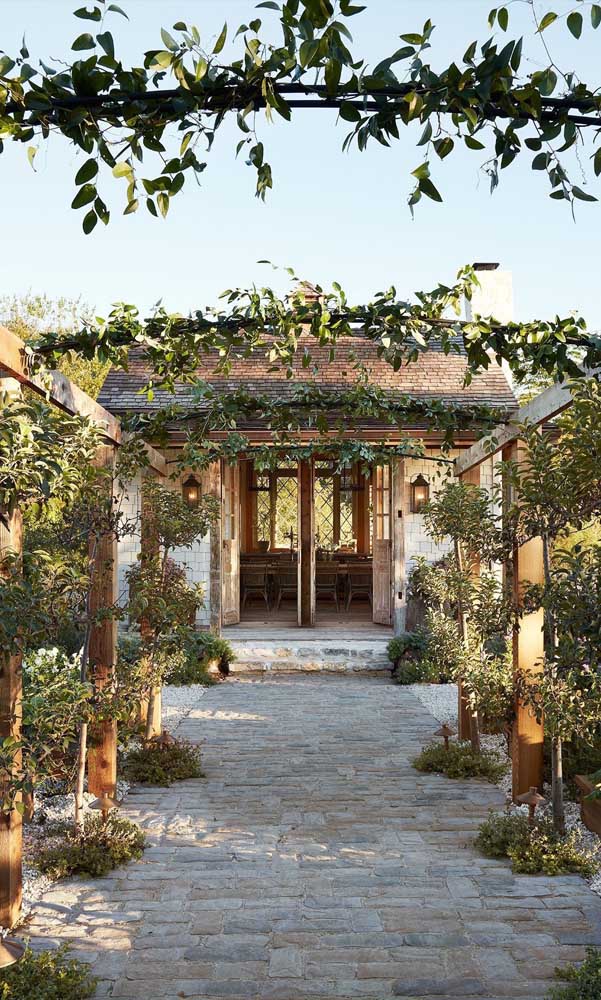 La maison de style rustique a apporté une tonnelle en bois juste à l'entrée.