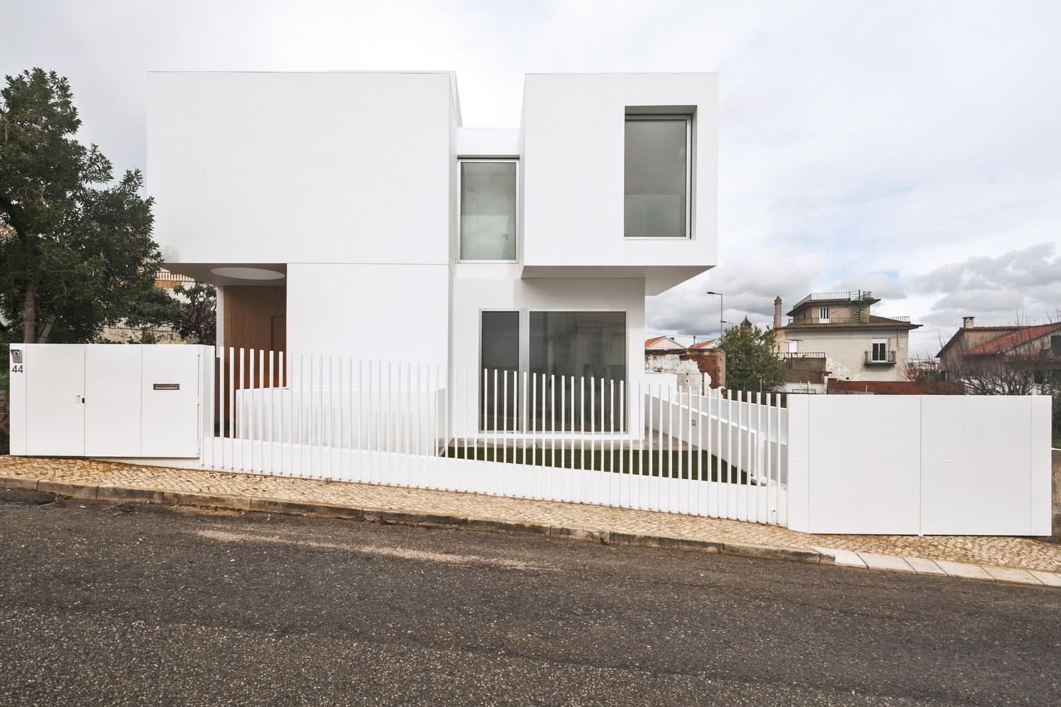 Portão vazado com gradil branco.