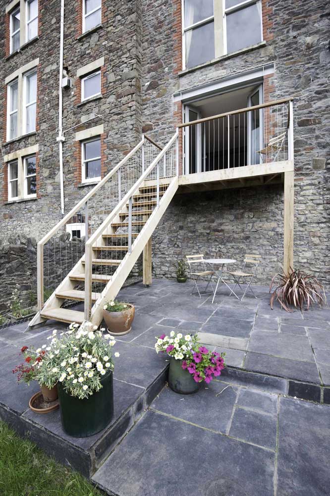 La rusticité de la maison en briques correspondait parfaitement aux petits pétunias en pot sur le trottoir.