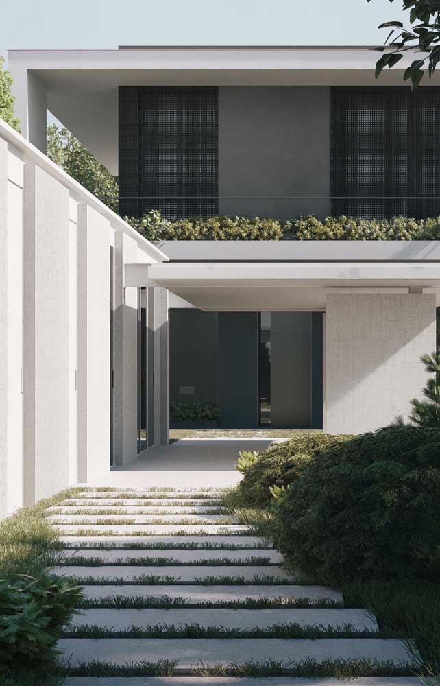 Vue d'entrée d'une maison en maçonnerie de deux étages de style contemporain avec jardin exclusif