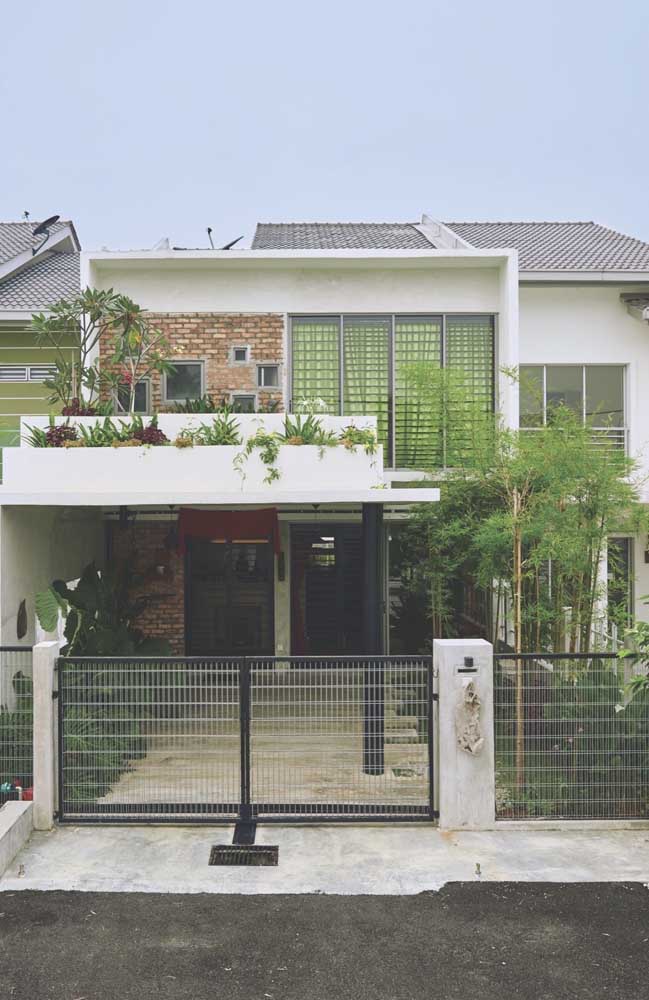 Modèle de maison en maçonnerie comprenant l'utilisation de briques apparentes, balcon, garage couvert et jardin sur l'avant-toit de la façade