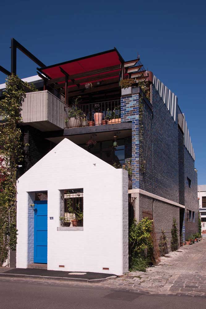 Petite maison en maçonnerie à deux étages avec terrasse ouverte finie en céramique de brique colorée