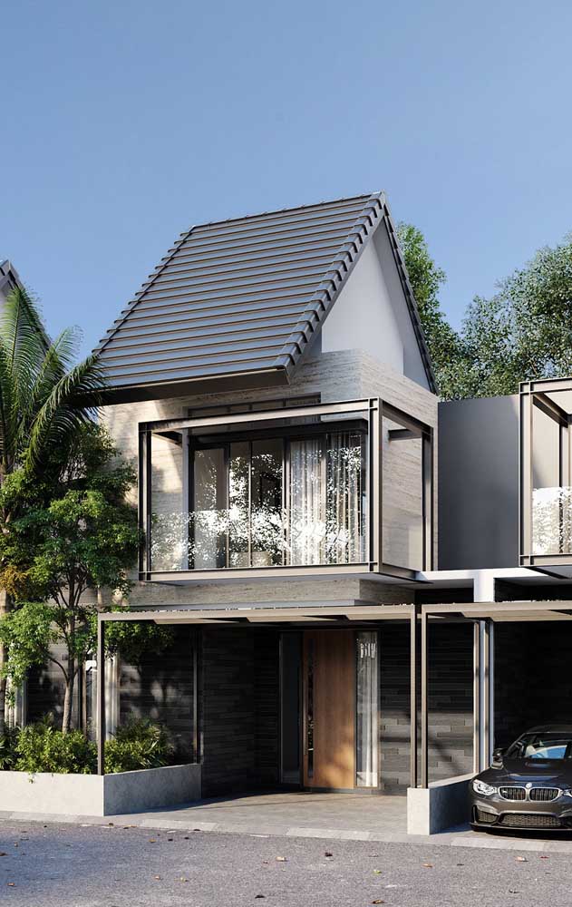 Maison préfabriquée en maçonnerie avec structures en acier apparentes et toit colonial