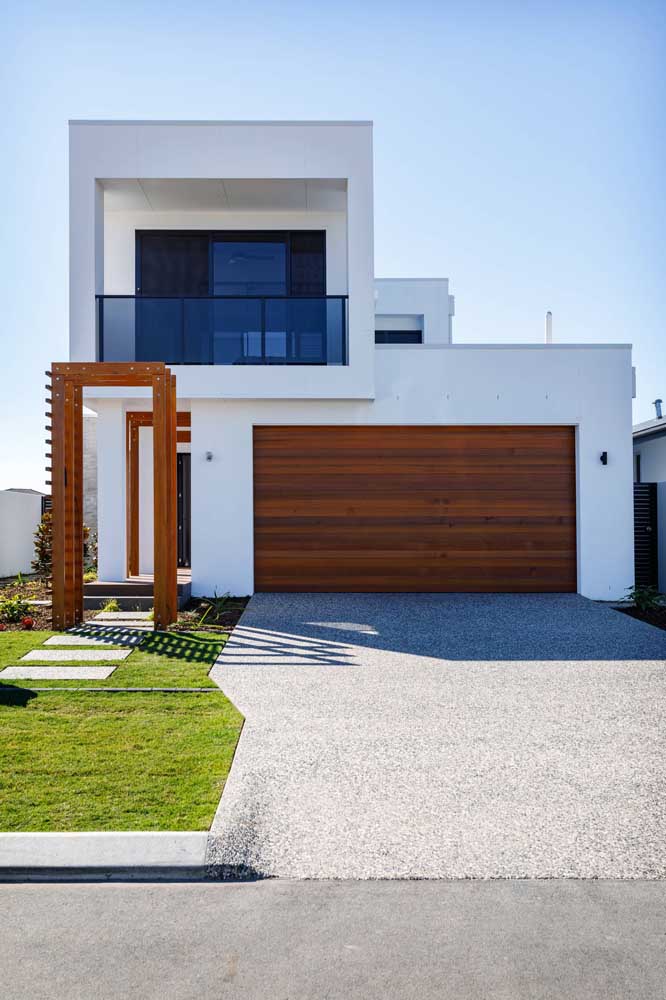 Façade d'une maison moderne en briques minimaliste avec portail en bois vers le garage intérieur