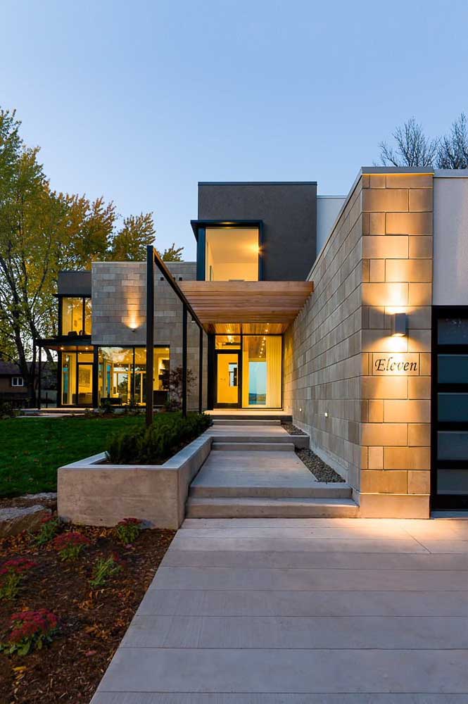 Maison en maçonnerie avec couloir en blocs de béton apparent; point culminant pour l'éclairage spécial sur la façade