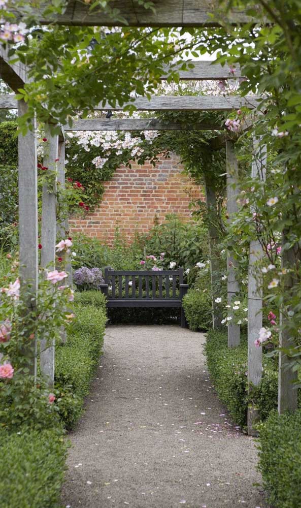 Un chemin dans le jardin mené par la tonnelle en bois